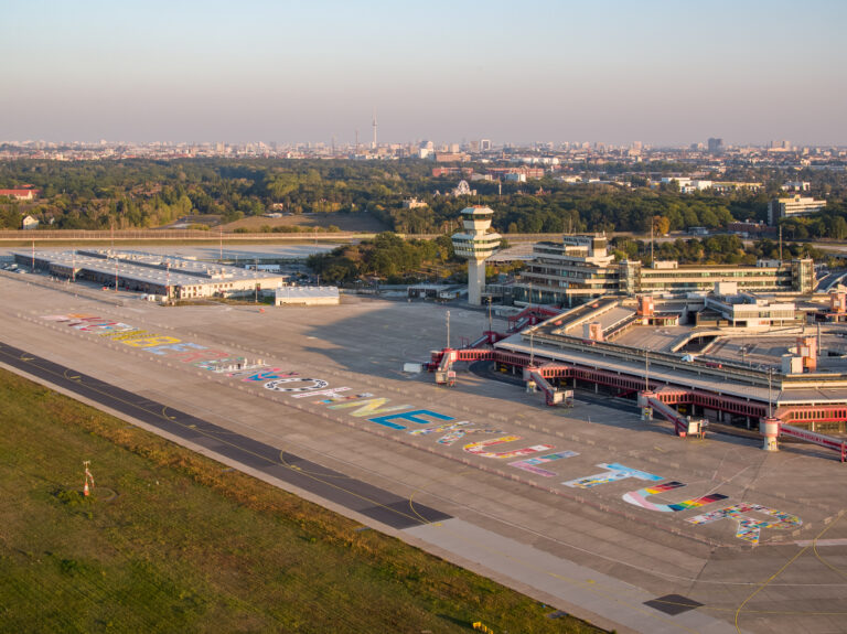 Blick von oben auf das Flughafengebäude und das Flugfeld.