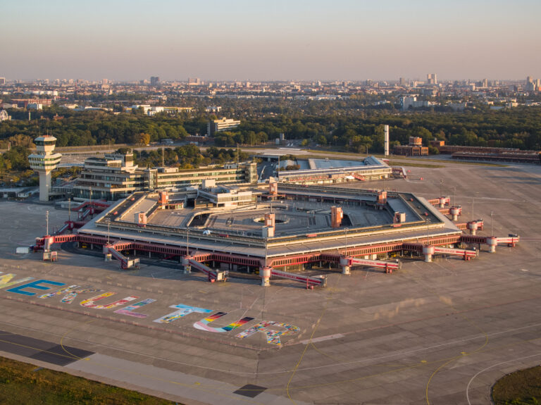 Blick von oben auf das Flughafengebäude und das Flugfeld.