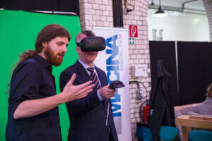 Parlamentarischer Abend: Ein Mann ohne VR-Brille erklärt einem Mann mit VR-Brille etwas