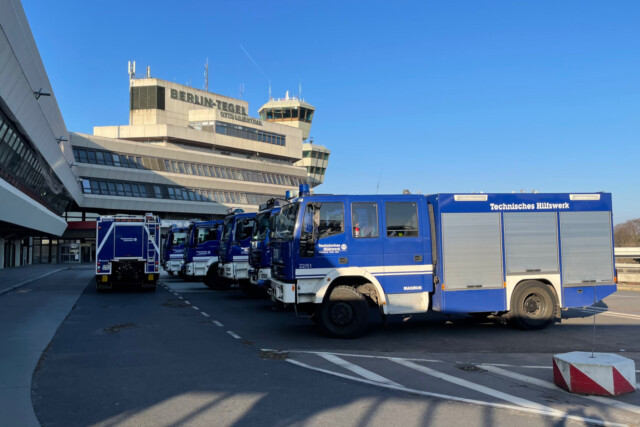 Mehrere blaue Fahrzeuge des Technischen Hilfswerk parken auf dem Gelände von Berlin TXL