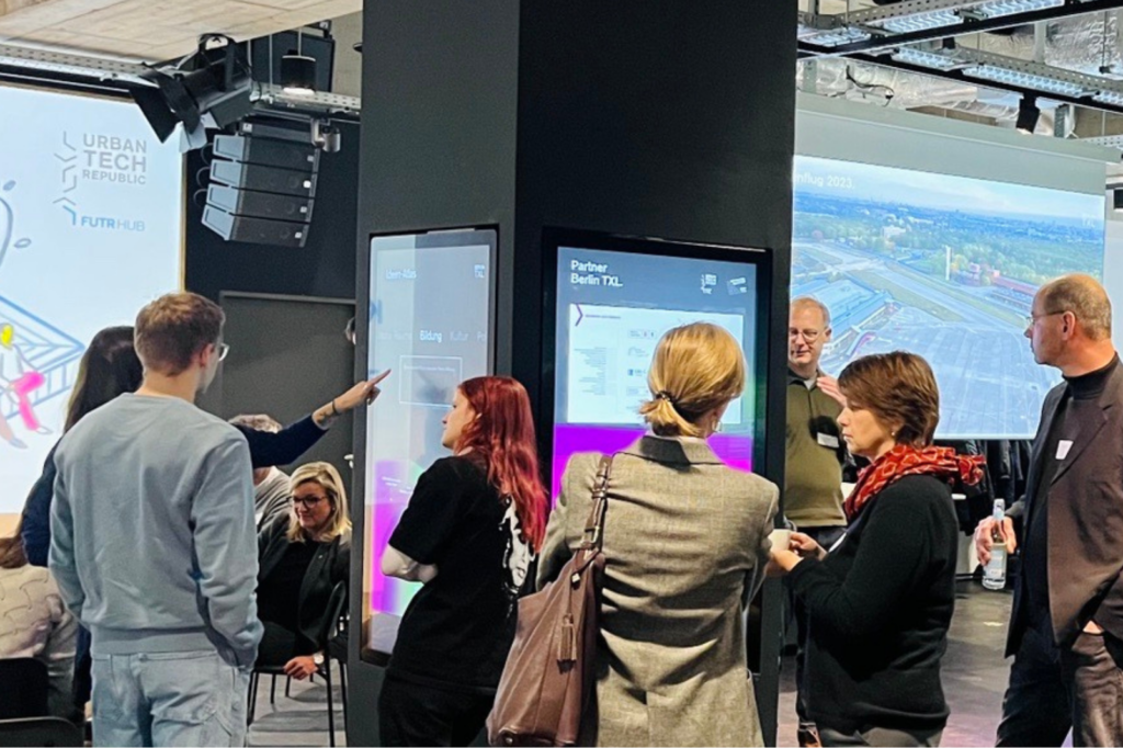 Menschen unterhalten sich beim Netzwerktreffen im Infocenter Berlin TXL.