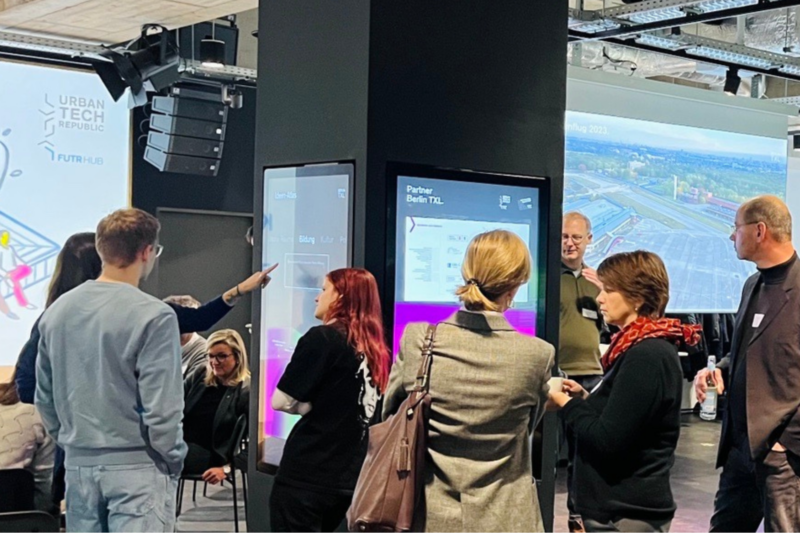 Menschen unterhalten sich beim Netzwerktreffen im Infocenter Berlin TXL.