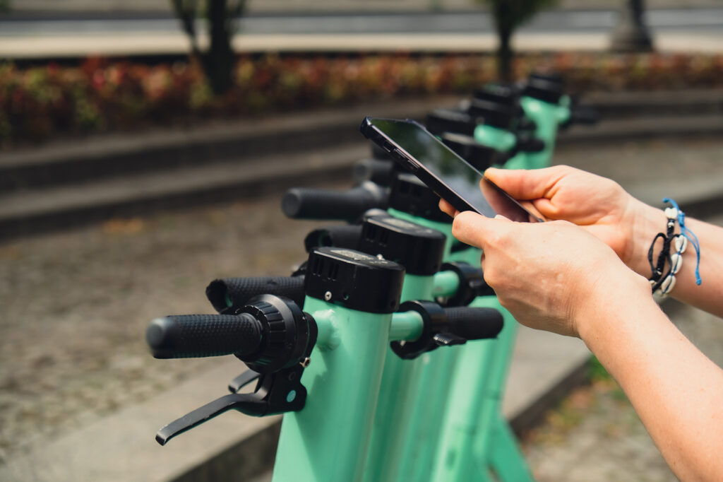 Eine Person bucht einen Bolt E-Scooter über die App um in Berlin TXL zu fahren.