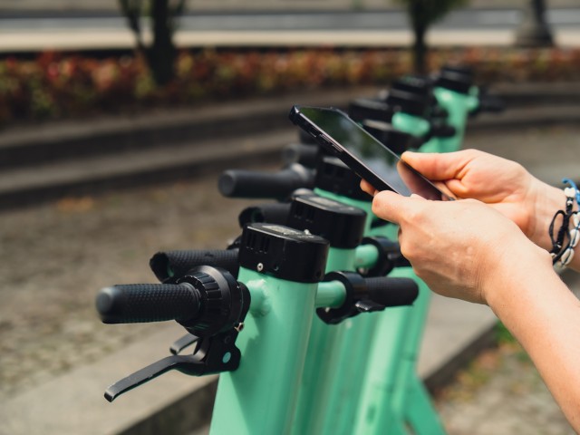 Eine Person bucht einen Bolt E-Scooter über die App um in Berlin TXL zu fahren.