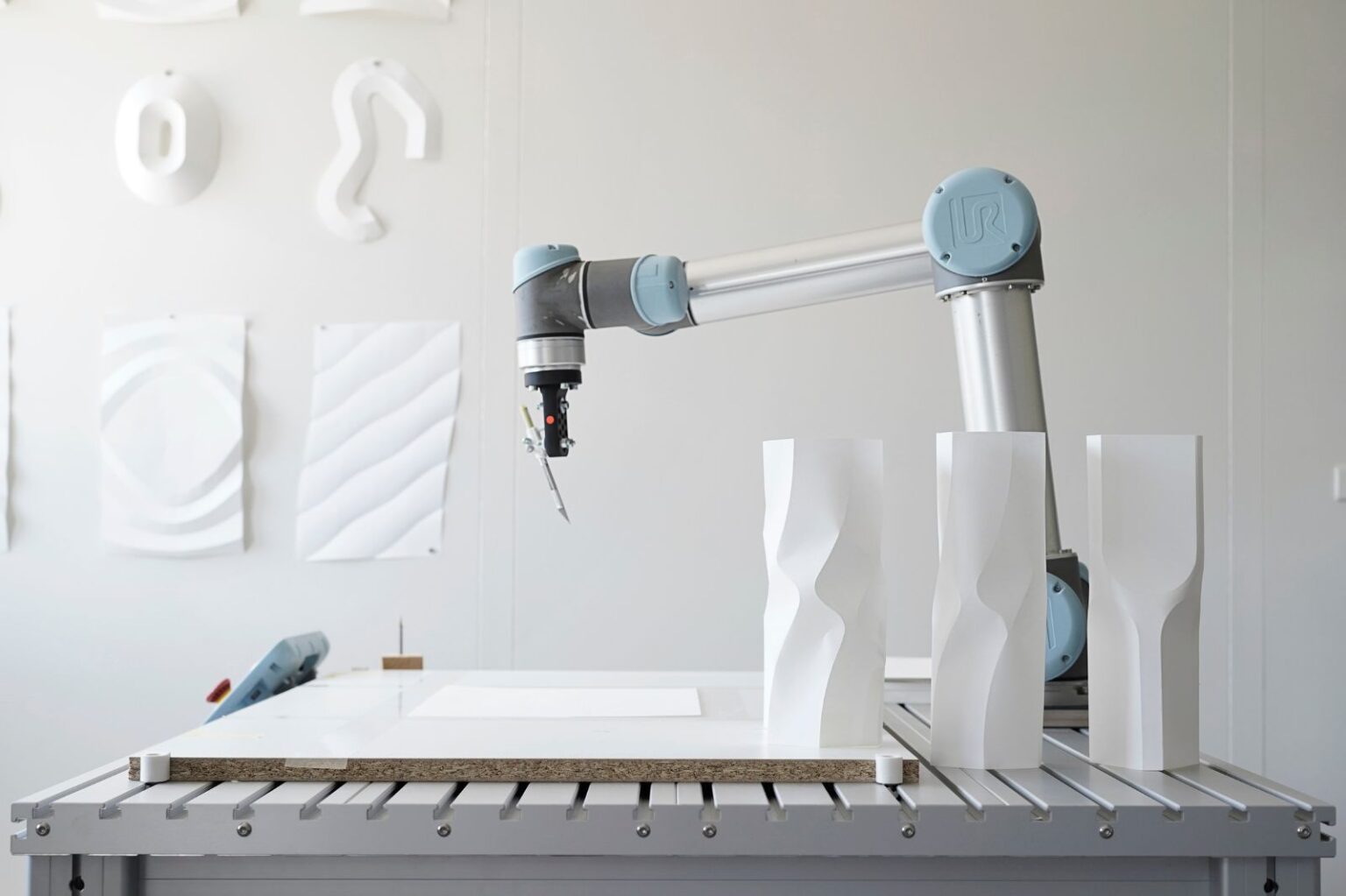 Ein Roboterarm fertigt kunstvolle Papierinstallationen in einem Design-Studio.